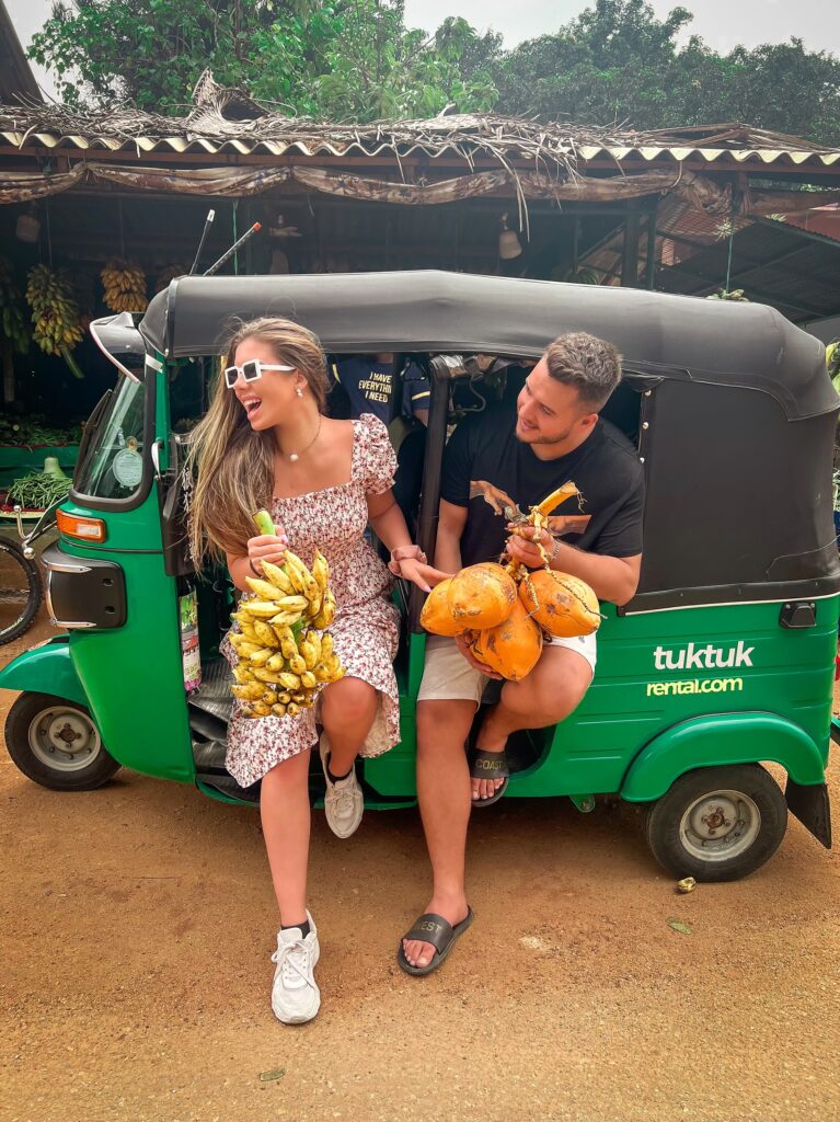 A tuktuk with the couple inside it buying fruits