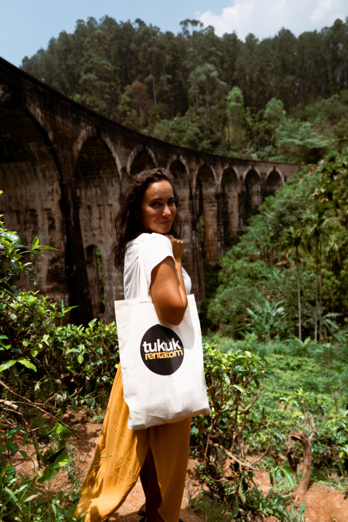 a lady with tuktuk rental bag and Nine Arch bridge in the background